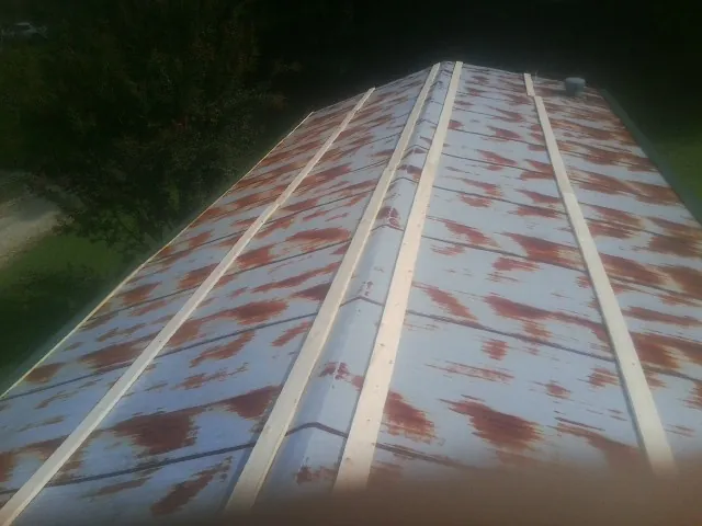 Rusted metal roof panels with new wood purlins before replacement — Storm Damage Roof Repair in Huntly by Roofing Brothers