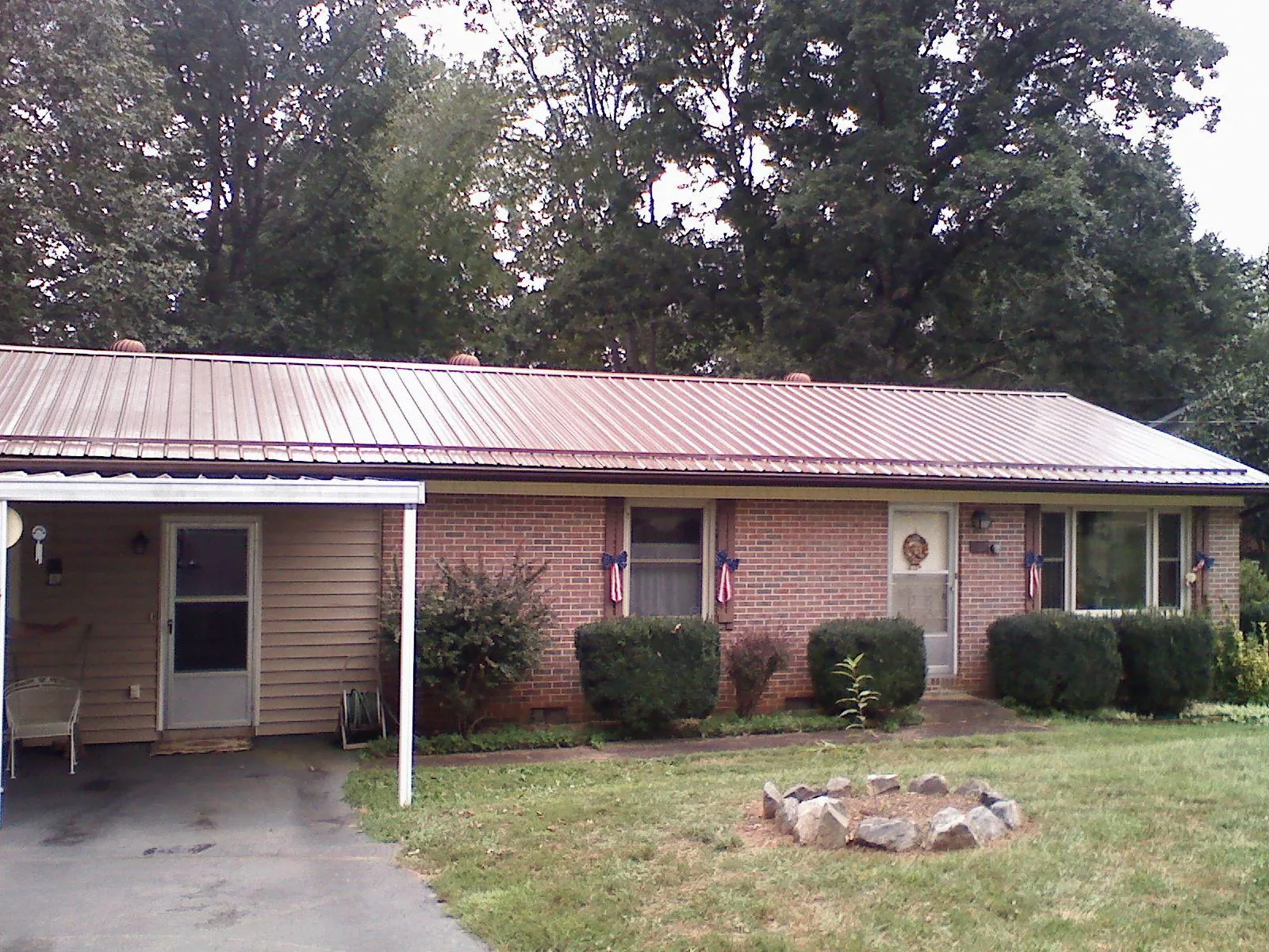 Bronze metal roof and carport on a brick ranch home — Roof Repair work by our crew in Huntly