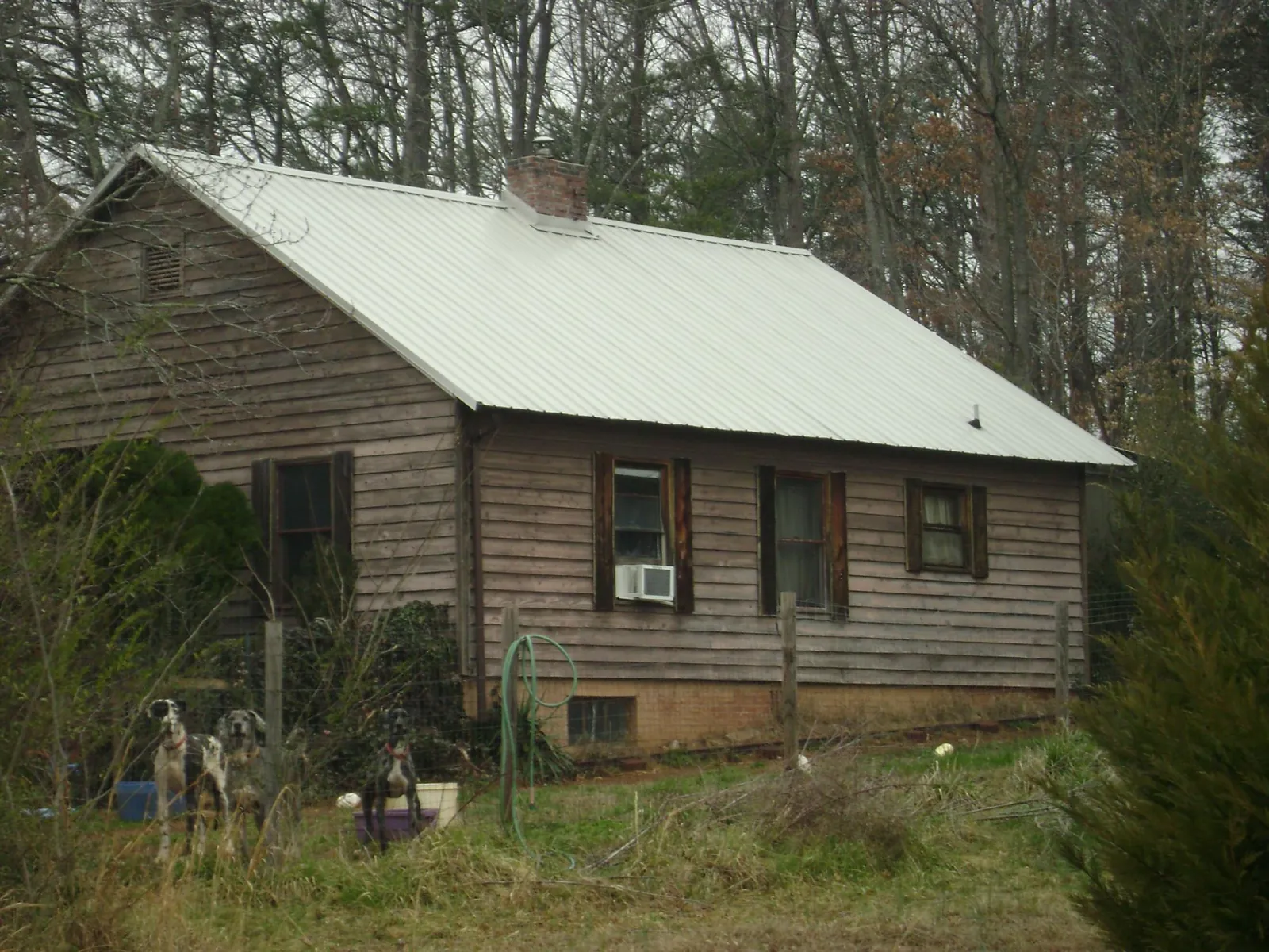White metal roof on an old wood sided farmhouse, from a Metal Roof Installation job in Huntly